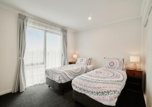特卡波湖Star View的一间卧室设有两张床和大窗户