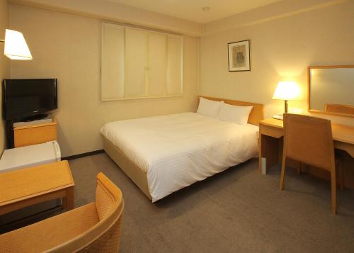 大川福冈大川微笑经济型酒店的酒店客房,配有床和电视