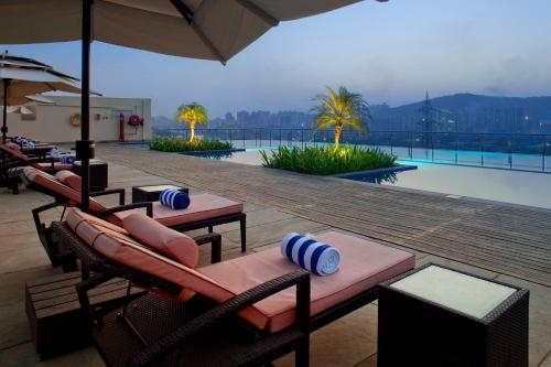 孟买孟买国际机场假日酒店的一个带游泳池、椅子和游泳池的度假村
