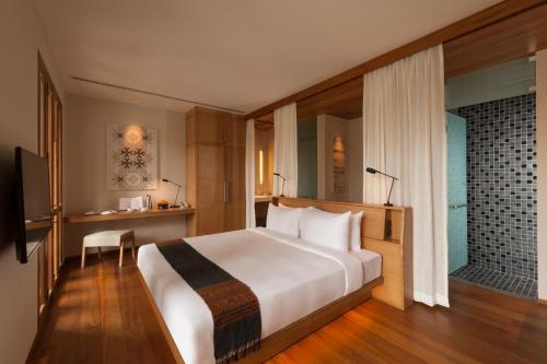 琅勃拉邦Avani+ Luang Prabang Hotel的卧室设有一张白色大床和一扇窗户。
