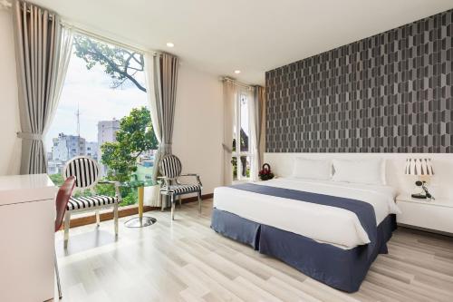 胡志明市Lam Kinh Hotel的酒店客房设有一张床和一个大窗户