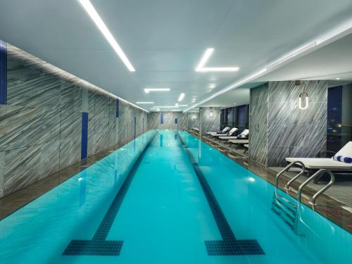长沙长沙会展诺富特酒店的大楼内的一个蓝色海水游泳池