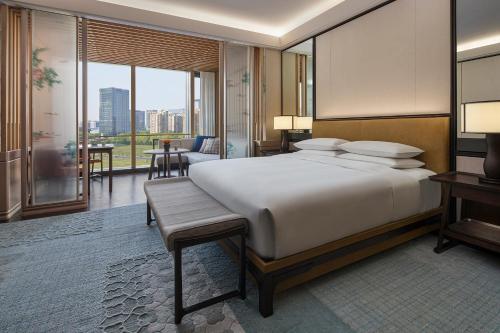 苏州苏州柏悦酒店的一间卧室设有一张大床和一个大窗户