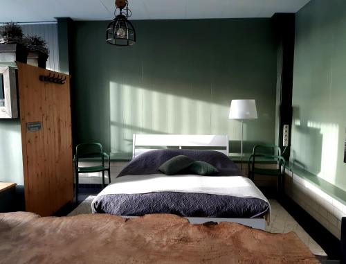 OpmeerMiddelpunt Opmeer的一间卧室配有一张带绿色墙壁的床