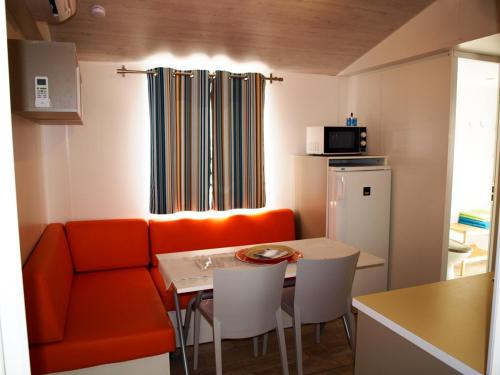 斯维蒂尤拉伊Mobile home Happy days的客厅配有橙色沙发和桌子