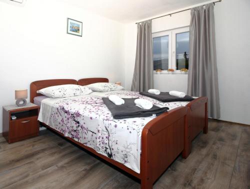 西利皮Apartment Milenka的一间卧室配有一张带白色床单的床和一扇窗户。