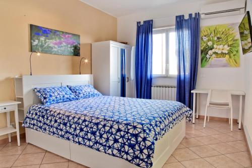 圣格雷戈廖迪卡塔尼亚B&B Etna Europa的一间卧室配有一张带蓝色棉被的床