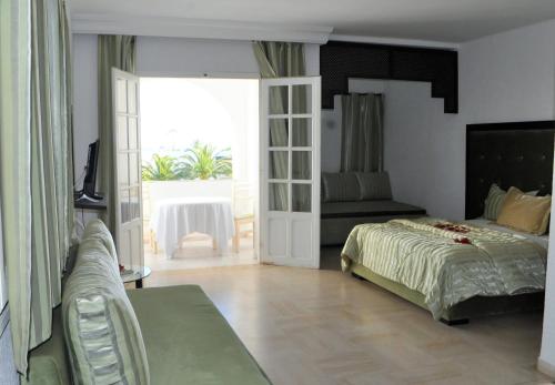 比塞大艾因马里亚姆公寓的一间卧室设有一张床和一个滑动玻璃门