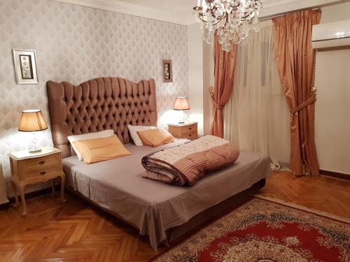 十月六日城Elite Homes 3BR Garden Apartment Families Only的一间卧室配有一张大床和大床头板