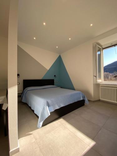 坎诺比奥Azalea Appartamenti的一间卧室设有一张床和一个大窗户