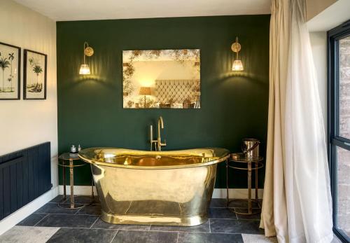 卡莱尔Tarn End Cottage 8, Talkin Tarn, Brampton的绿色浴室内的金色浴缸,配有镜子