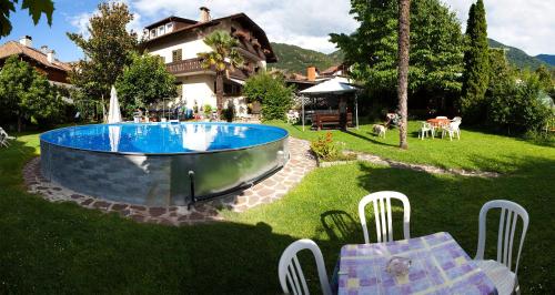 奥拉Gasthaus Abram的一个带游泳池和房子的后院