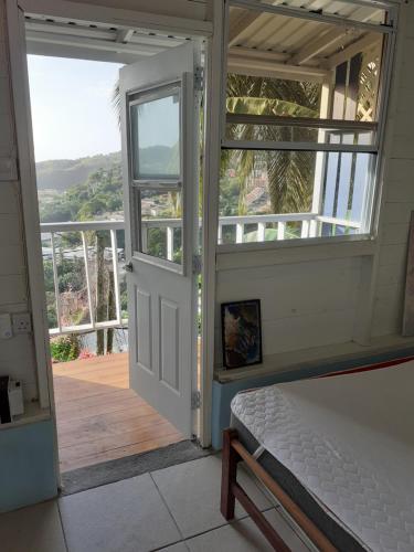 圣乔治Cosy Hut的卧室设有通往阳台的门