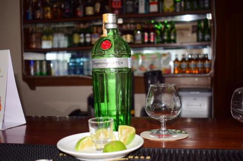 MeruMeru Slopes Hotel的一瓶绿色葡萄酒,旁边是一盘石灰片