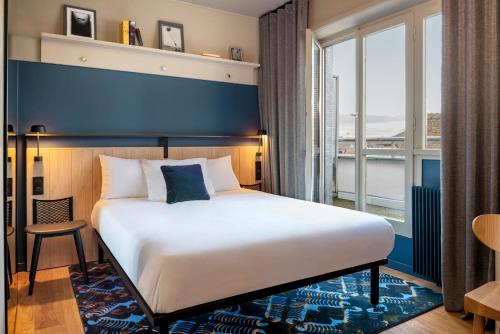 斯特拉斯堡Hotel Kaijoo by HappyCulture的一间卧室设有一张大床和一个大窗户
