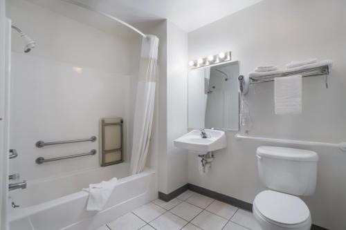 格林里弗华美达连锁酒店的白色的浴室设有卫生间和水槽。