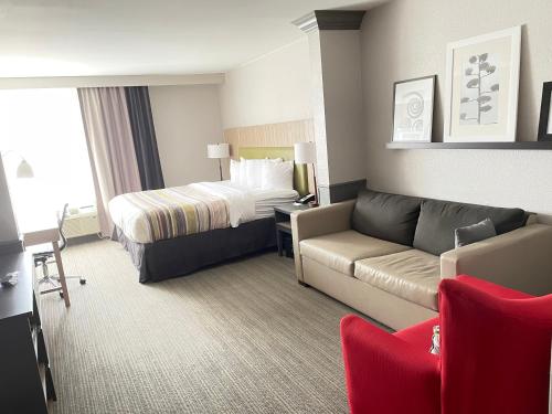WintervilleCountry Inn & Suites by Radisson, Greenville, NC的酒店客房,配有床和沙发