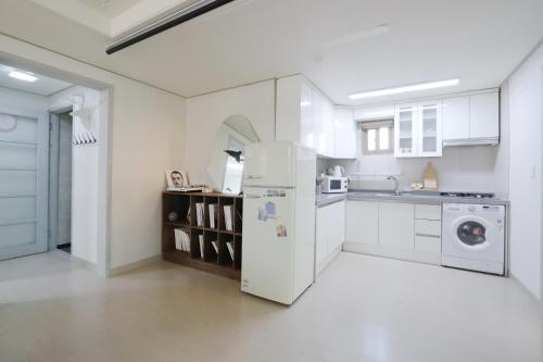 首尔Lovely House Hongdae的白色的厨房配有冰箱和水槽