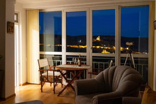 大特尔诺沃Tsarevets panoramic apartments Veliko Tarnovo的客厅设有桌子和大窗户