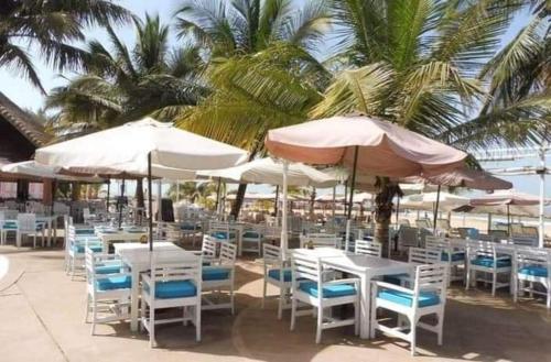 萨利波图尔safari village case 29的海滩上摆放着一束带遮阳伞的桌椅