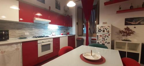 巴科利Casa baja的厨房配有红色橱柜和一张桌子,上面有盘子