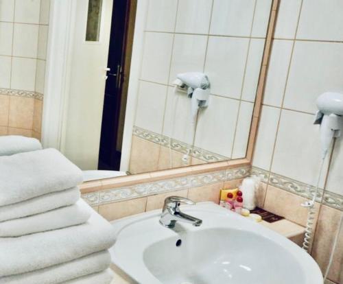 克拉科夫马特约科酒店的浴室配有盥洗盆、镜子和毛巾