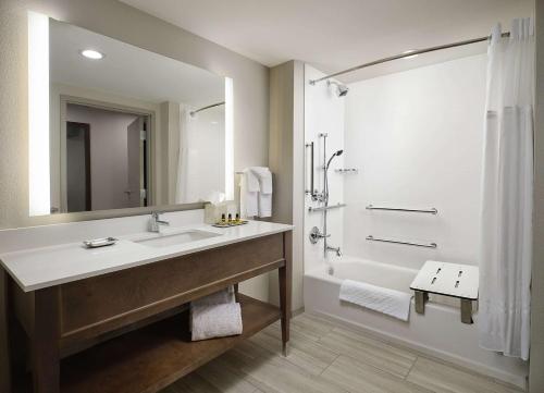 奥利夫布兰奇Best Western Plus Desoto的浴室配有水槽、淋浴和浴缸。