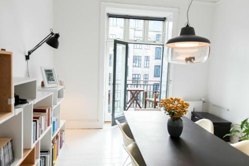 哥本哈根ApartmentInCopenhagen Apartment 1357的一间房间,桌子上放着花瓶