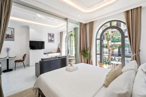 胡志明市The Royal Homies - Phu My Hung的一间带白色大床的卧室和一间客厅