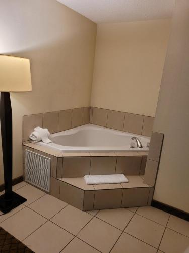 蒙哥马利如家旅馆&套房酒店的浴缸,带灯和毛巾的房间
