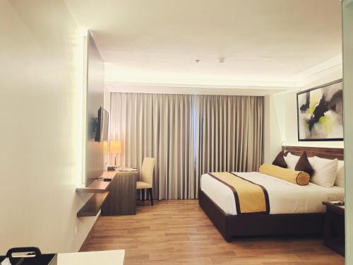 卡兰巴马西亚诺酒店的配有一张床和一张书桌的酒店客房