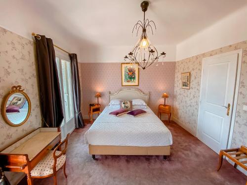 昂蒂布波斯蒂莱恩酒店的一间卧室配有一张床、镜子和吊灯