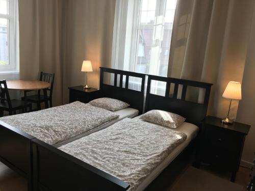 比亚沃加德Belgard- House 32的卧室内的两张床,配有两盏灯和一扇窗户
