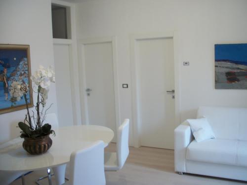 阿科马松内攀岩之家公寓的白色的客厅配有桌子和白色沙发