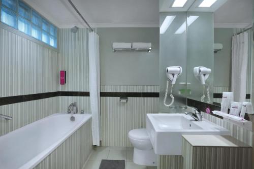 万隆奇哈佩拉斯普利米尔法福酒店的带浴缸、卫生间和盥洗盆的浴室