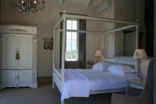 弗朗斯胡克Franschhoek Pass Villa的卧室配有白色的天蓬床和窗户。