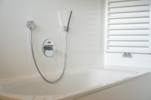 圣坎迪朵Chalet Tolder的白色浴室设有淋浴和浴缸。