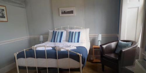 利扎尔德托普豪斯宾馆的一间卧室配有一张带蓝色和白色枕头的床和椅子