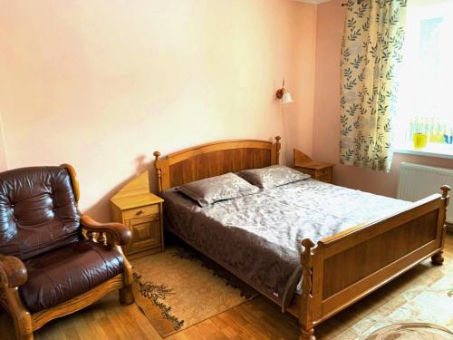 莫申Зелений Дім - ViriDi House的一间卧室配有一张床和一把椅子
