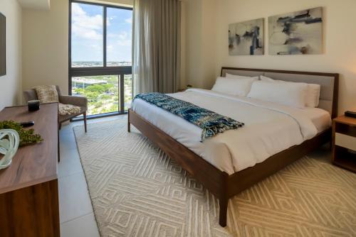 迈阿密Provident Grand Luxury Short-Term Residences的一间卧室配有一张床、一张书桌和一个窗户。