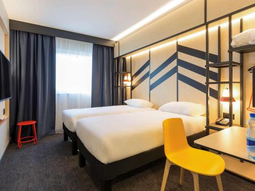 日内瓦日内瓦帕尔展览中心机场宜必思尚品酒店的酒店客房,设有两张床和一张黄色椅子