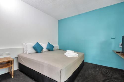 达尔文Capitanos的一间卧室配有一张蓝色墙壁的床