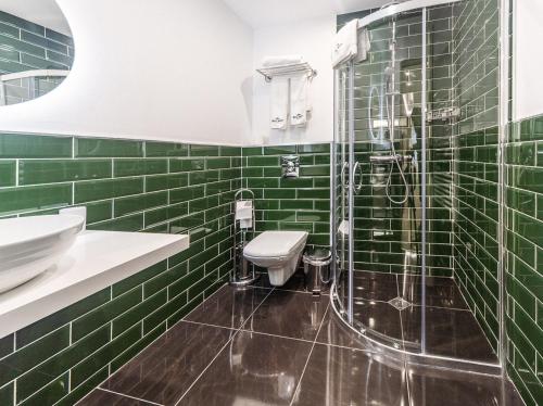 斯利文Monte Vedetta的绿色瓷砖浴室设有卫生间和淋浴。