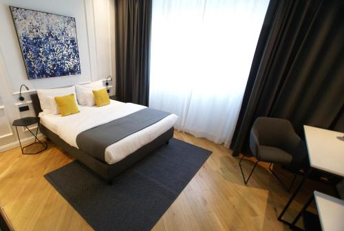 萨格勒布Fingerprint Tree Apartments - Delux的一间卧室配有一张带黄色枕头的床和一扇窗户