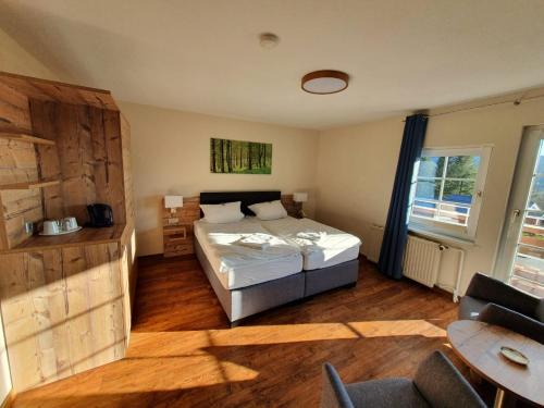 哈嫩克利博克斯维斯瓦尔德豪斯酒店的一间卧室配有一张床、一张桌子和一个窗户。