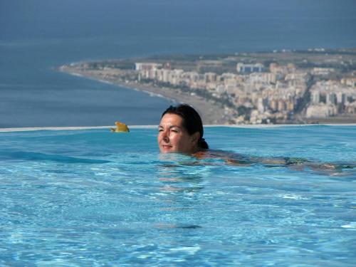 赛阿隆加Villa Perla Blanca的一位女性在一座城市的游泳池里