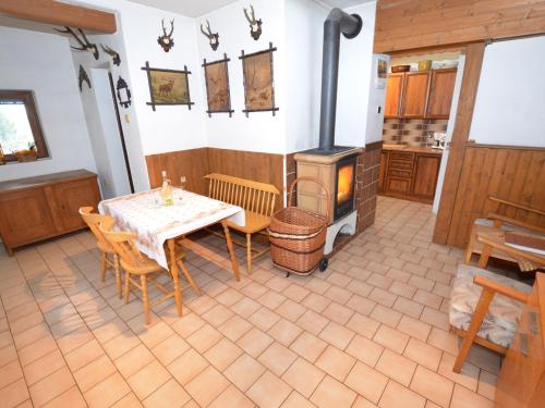 小斯卡拉small holiday home at the edge of the forest的厨房配有桌子和燃木炉。