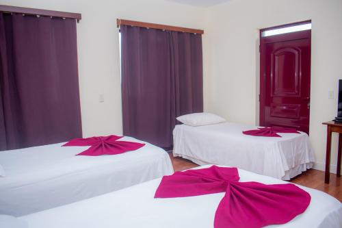 圣菲利佩Hotel Santos Pina的一间设有两张红色弓床的房间