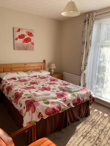 大雅茅斯Kings Lodge Hotel的一间卧室配有一张带花卉床罩的床