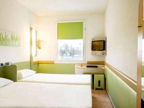 华沙ibis budget Warszawa Centrum的酒店客房设有两张床和窗户。